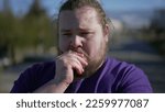 Small photo of Concerned young man standing outdoors feeling anxiety. Closeup face tracking shot on overweight male person with preoccupied expression