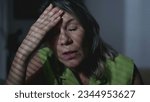 Small photo of Anxious mature woman struggling with inner thoughts ruminations. Preoccupied expression of a middle-aged female person struggling with mental illness sitting by window at home