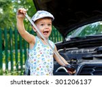 Funny kid with tape near open car bonnet