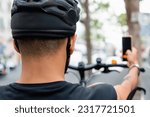 Cyclist looking at the phone as if looking for a map or a route. Sport and technology concept