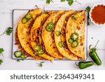 Small photo of Birria quesadilla with cheese and jalapeno pepper slices soaked in Mexican chili peppers deep, slow cooked for hours in one pot served in wheat tortillas on traditional way