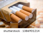Small photo of Cigarettes in a pack. Yellow filter. Harm to health. Bad habit. A pack of cigarettes on the table. open pack of cigarettes.