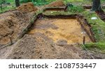 Small photo of Archaeological excavation in a forest. A large plundering pit dug by archaeologist at an archaeological site. Legal historic excavations. Heritage concepts.
