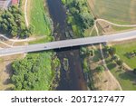 Aerial high angle view of car driving over bridge. River flowing under bridge