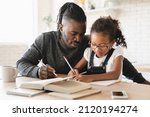 Small photo of Tutoring homeschooling concept. African father dad childminder helping daughter student with homework, drawing together, e-learning, preparing for school art project at home.