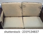 Small photo of Old worn brown leather sofa. An old tattered shabby sofa in a deplorable state