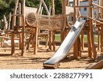Children Playground with Modern Slide, Rope Net Bridge, Climbing Swings, Climbers. Empty Wooden Playground made of Eco Materials - Wooden Tree trunk Logs Robinia.