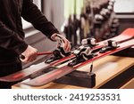 Skis for Rent. Ski Rental Service. Ski Repair Shop Worker Adjust the Bindings and Equipment with Screwdriver. Ski Workshop Service.