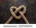 Small photo of Celtic knot in the shape of a rope heart. Concept of creative unity, faith and protection.