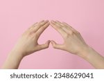Female hands make a heart sign...