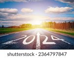 Small photo of New year 2024 or straightforward concept. Text 2024 written on the road of asphalt road at sunset.Concept of planning and challenge, business strategy, opportunity ,hope, new life change.
