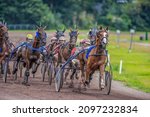 Small photo of GRONINGEN NETHERLANDS - AUGUST 1st, 2021: Riders compete during their harness racing or horse sulky race at the "Royal Drafbaan Groningen"