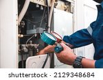 Small photo of Heat and Air Conditioning, HVAC system service technician using measuring manifold gauge checking refrigerant and filling industrial air conditioner after duct cleaning maintenance outdoor compressor.
