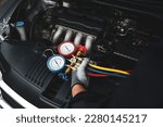 Small photo of Car care maintenance and service, Hand technician auto mechanic using measuring manifold gauge check refrigerant and filling car air conditioner to fix repairing heat conditioning system.