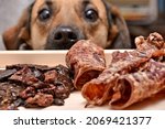 Natural treats for pets. dried meat products to feed and motivate dogs. the dog in the background looks with interest. High quality photo