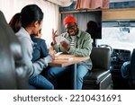 A playful father wins the card game against his son and wife while sitting in their van. A happy multicultural family having fun together in RV.
