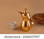 Small photo of dallah is a metal pot with a long spout designed specifically for making Arabic coffee, Saudi coffee wood background, arabic coffee and dates.