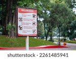 Small photo of South Jakarta, Indonesia - February 3rd, 2023: Signs in Mataram Park in Indonesian which prohibit staying in the park, trading, damaging facilities and trees, and committing immoral acts.