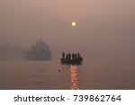 A landscape view of the brahmaputra river national park of the Sundarbans  mangrove forest, one of the largest such forests in the world in a foggy day with a small boat full of people, bangladesh