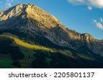 Small photo of the morning sun illuminate the clouds and the peaks of Swiss mountains around Adelboden. first light in the valley from Boden, under the high mountain big wager, with green meadows, forests and rocks