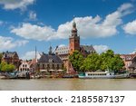Small photo of Leer, Germany. Panoramic view from Leda river on city hall, old weigh house in dutch classical baroque style, tourist harbor and bridge