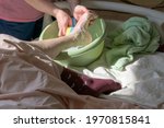 Small photo of Washing the feet of a bedridden patient. Nurse washes the leg over the basin with a washcloth with soapy foam. Curved foot. Concept of caring for a bedridden patient with dementia, stroke.