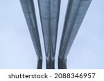 Small photo of Metal pipes. Stainless steel casing. Perspective view against the blue sky. Concept gas pipeline, oil pipeline, fuel pipe, conduit.