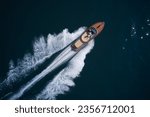 Luxurious wooden boat fast movement on dark water. Classic Italian wooden boat fast moving aerial view. Top view of a wooden powerful motor boat. Large expensive varnished wooden boat top view