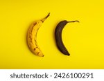 Small photo of Rotten bananas on a yellow background from above. Banana that are beginning to spoil and banana that have already spoiled. Yellow and brown spoiled bananas.