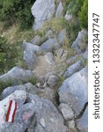 Small photo of Marked difficult mountain trail with large stones of Mirabela Fortress in Omis Croatia on a summer day. Concept trekking and hiking trips
