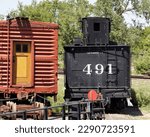 Small photo of Tender From Steam Locomotive 491 Next to an Old Boxcar in a Train Yard