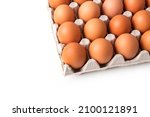 Egg box with brown eggs isolated on white background. Fresh organic chicken eggs in carton pack with copy space.