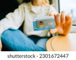 Small photo of DeutchlandTicket in hands, woman holding new German subscription travel card. Gelsenkirchen, Germany - May 11 2023