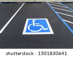 Freshly resurfaced and repainted handicap parking space in a parking lot. The number of handicap spaces increases with the size of the lot, requiring roughly one handicapped spot per 25 spaces.