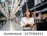 Woman worker using digital tablet checking the stock inventory, Smart warehouse management system, Supply chain and logistic network technology concept.