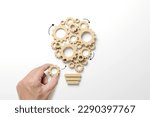 Small photo of Business process and workflow automation with flowchart. Hand holding wooden cog flowing process management lightbulb shape on white background