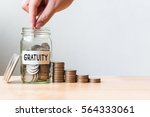 Small photo of Hand putting coin in jar word gratuity with money stack, Concept business finance and investment