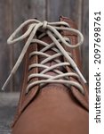Small photo of lacing with banter on tall men's shoes close-up on a wooden background