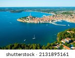 Tower of St. Euphemia church surrounded by traditional buildings of Rovinj. Bright red rooftops of houses in Croatian town in Adriatic sea. Aerial panorama