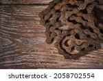 Old rusty bicycle chain on a wooden background
