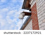 Small photo of Spontaneous ventilation pipe in a house with icicles and ice in winter. The ventilation pipe is insulated in winter weather. Modern design.