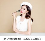 Small photo of Cute Asian woman with perfect clear fresh skin. Pretty girl model wearing white beret and natural makeup on beige background. Cosmetology, beauty and spa, wellness, Plastic surgery.