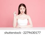 Small photo of Young Asian woman long hair with natural makeup on face have plump lips and clean fresh skin on isolated pink background. Portrait of cute female model in studio. Facial treatment, Cosmetology.
