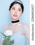 Small photo of Princess concept. Asian woman with korean makeup on face have plump lips and clean fresh skin on isolated blue background. Portrait of cute female model in studio. Facial treatment, Cosmetology.
