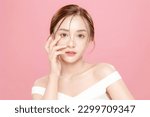 Young Asian beauty woman pulled back hair with korean makeup style touch her face and perfect skin on isolated pink background. Facial treatment, Cosmetology, plastic surgery.
