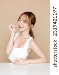 Small photo of Young Asian beauty woman pony tail hair with korean makeup style on face and perfect skin show mini heart on isolated beige background. Facial treatment, Cosmetology, Spa, Aesthetic, plastic surgery.