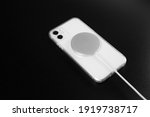 white phone and wireless charging on black background