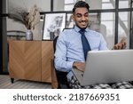 Man smiling at laptop sitting in chair