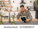 Small photo of Joyless military man with a photograph in the hand