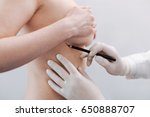 Small photo of Delicate scrupulous plastic surgeon drawing special marks
